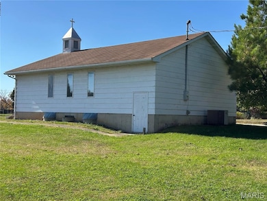 View of property exterior with a lawn and a central AC unit