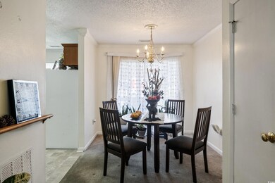 Dining room featuring crown molding, a textured ce
