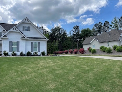View of side of property with a lawn and a shingled roof