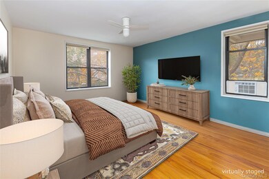 Bedroom with light wood-style flooring, ceiling fan, and cooling unit