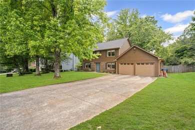 View of front facade with driveway, an attached garage, and brick siding