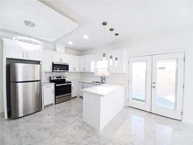 Kitchen with a sink, a peninsula, stainless steel appliances, tasteful backsplash, and marble finish floor