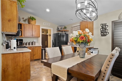 Dining area with vaulted ceiling, a chandelier, and recessed lighting