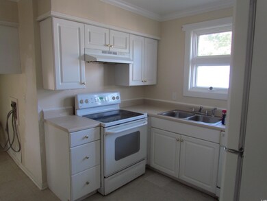 Kitchen featuring white cabinetry, electric range,