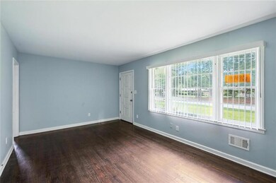 Spare room featuring dark wood-type flooring and healthy amount of natural light