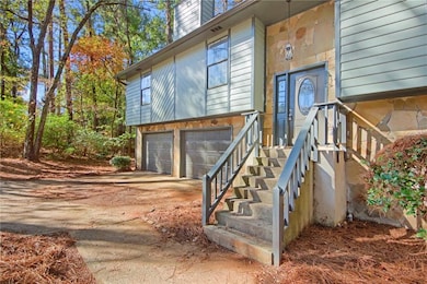 Doorway to property featuring concrete driveway, an attached garage, and a chimney