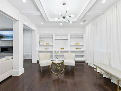Sitting room featuring beamed ceiling, a chandelier, dark wood-style flooring, a fireplace, and recessed lighting