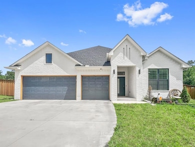 View of front of property featuring brick siding, concrete driveway, an attached garage, and a shingled roof