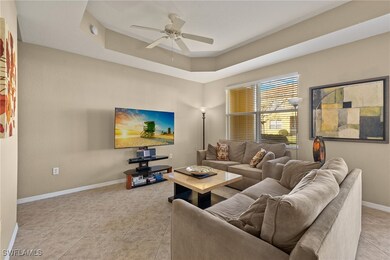 Living room featuring ceiling fan, a tray ceiling,