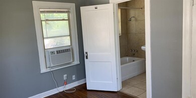 Bathroom with toilet, tiled shower / bath, hardwoo