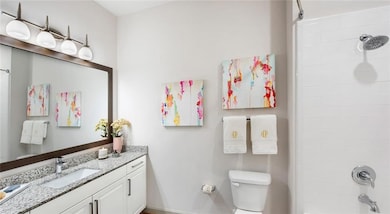 Bathroom featuring vanity, tiled shower, and toile