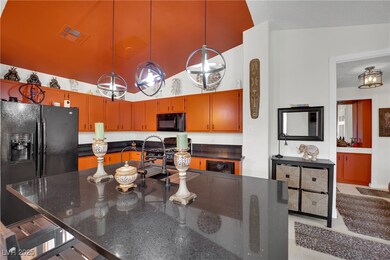 Kitchen with black appliances, wine cooler, hangin