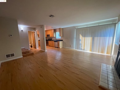 Unfurnished living room featuring light wood finished floors and baseboards
