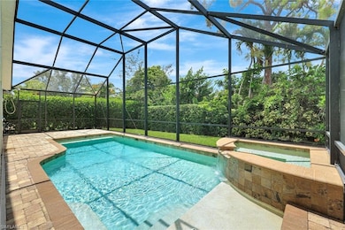 View of swimming pool with a pool with connected hot tub, a patio area, and a lanai