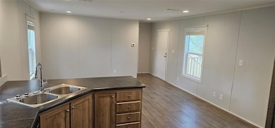 Kitchen with dark countertops, wood finished floo