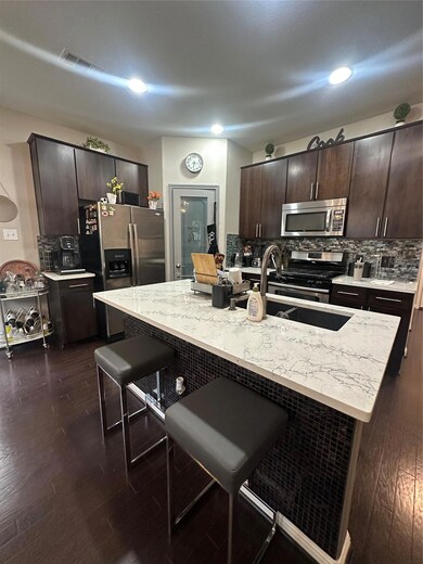 Kitchen with stove, a breakfast bar area, dark br