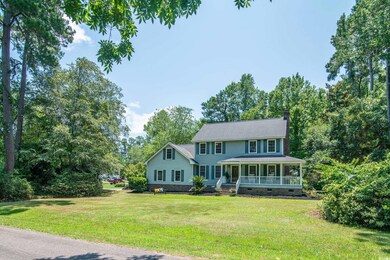 View of front facade with a front yard and covered