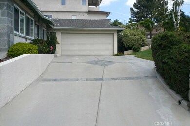 Driveway to garage, door to house on left
