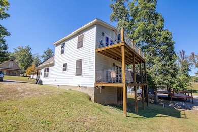 Rear view of property with a lawn, crawl space, a balcony, and a wooden deck