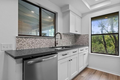Kitchen with dark countertops, dishwasher, light 