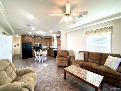 Living room with crown molding, a ceiling fan, and recessed lighting