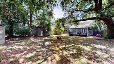 Fenced backyard featuring french doors, a deck, and an outdoor fire pit