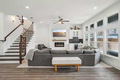 Living room featuring ceiling fan,  fireplace, & m