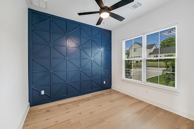 Unfurnished room featuring a decorative wall, lig
