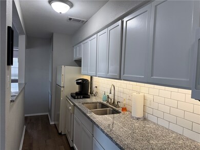 Kitchen with a sink, backsplash, dark wood-style f
