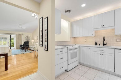 Kitchen featuring white cabinets, light wood-type 