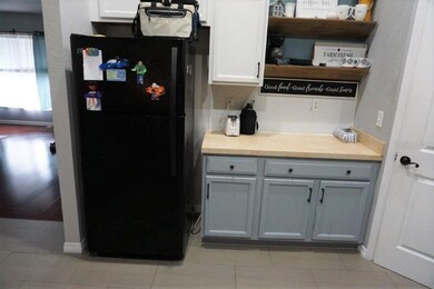 Counter between refrigerator and pantry offers handy work space for food prep.