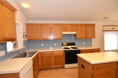 Kitchen featuring healthy amount of natural light, backsplash, gas stove, and light countertops