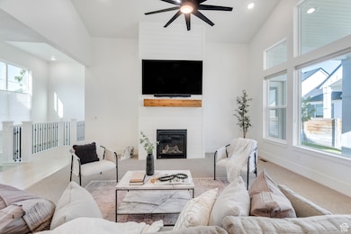 Living area featuring vaulted ceilings, expansive windows for natural light, recessed lighting, carpet floors, a large fireplace, and a ceiling fan