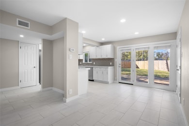 Kitchen featuring white cabinets, light countertops, tasteful backsplash, recessed lighting, and dishwasher