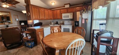 Kitchen with a wealth of natural light, white appliances, light countertops, and vaulted ceiling
