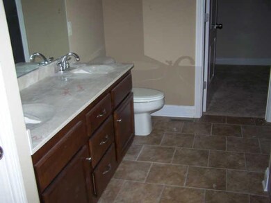 Master Bath with tile floors. Double sinks and cherry cabinets.