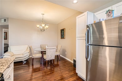Dining room with a chandelier, dark wood-style flooring, and recessed lighting