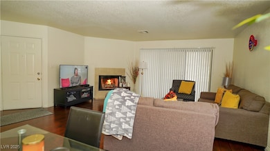 Living room with a tile fireplace, visible vents,
