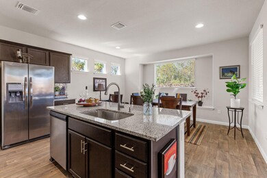 Kitchen featuring dark brown cabinetry, appliance