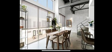 Dining space with a towering ceiling, tile walls,