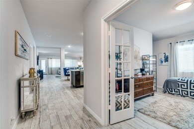 Corridor with baseboards, french doors, and wood f