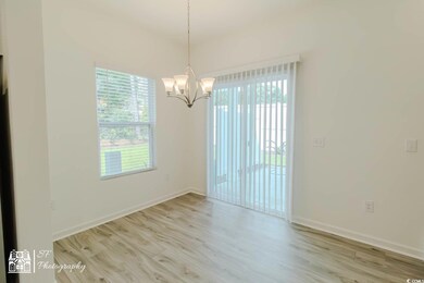 Spare room featuring a chandelier, wood finished floors, and baseboards