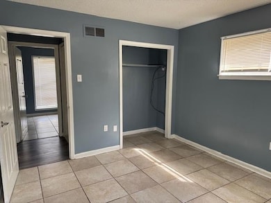 Unfurnished bedroom featuring baseboards, visible vents, a closet, and a textured ceiling