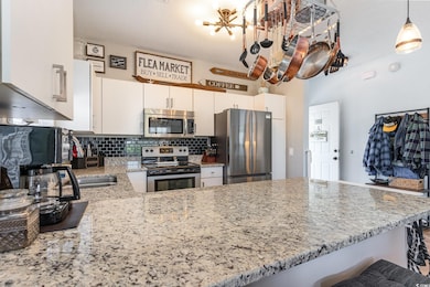 Kitchen featuring tasteful backsplash, white cabin