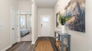 Entryway featuring dark wood finished floors, plenty of natural light, and baseboards