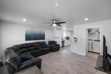 Living room with separate washer and dryer, light wood-style flooring, recessed lighting, and a ceiling fan