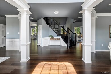 Entrance foyer featuring crown molding, dark hardw
