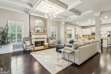 The heart of the home is the Open Concept Living Room, featuring a cozy Gas Log Fireplace, Coffered Ceilings, and Custom Wooden Shutters that let in loads of Natural Light.