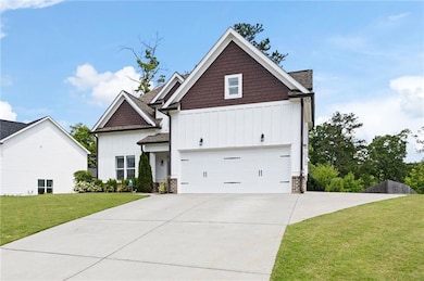 Craftsman inspired home featuring board and batten siding, concrete driveway, a front yard, and an attached garage with brand new insulated single garage door