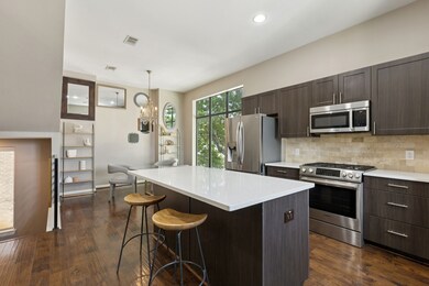 Kitchen featuring stainless steel appliances, dark brown cabinetry, a kitchen breakfast bar, hanging light fixtures, and recessed lighting